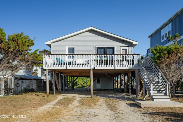3016 W Beach Dr, Oak Island, NC 28465 - coastal home with driveway, a carport, a deck, and stairs