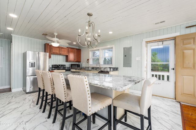 kitchen with stainless steel appliances, plenty of natural light, pendant lighting, and electric panel