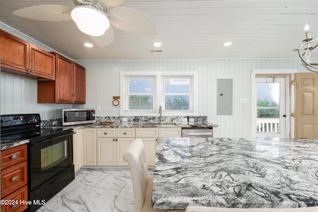 kitchen featuring wood walls, sink, cream cabinets, appliances with stainless steel finishes, and electric panel