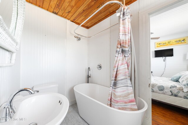 3016 W Beach Dr, Oak Island, NC 28465 - ensuite bathroom featuring a freestanding tub, wood finished floors, a sink, wooden ceiling, and a shower with curtain
