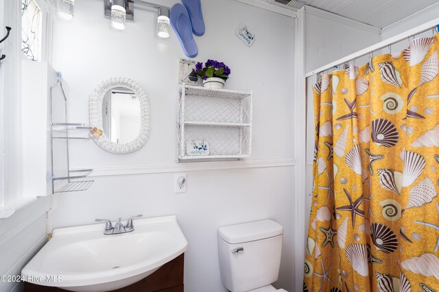 bathroom featuring ornamental molding, walk in shower, vanity, and toilet