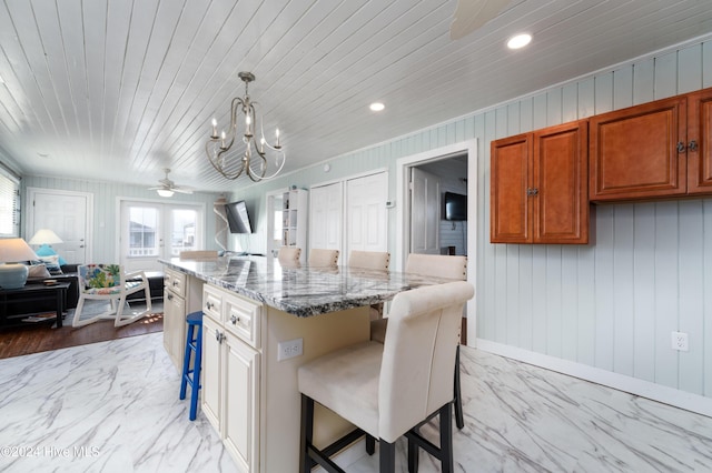 3016 W Beach Dr, Oak Island, NC 28465 - kitchen featuring light marble finish flooring, a kitchen breakfast bar, light stone counters, recessed lighting, and wooden ceiling