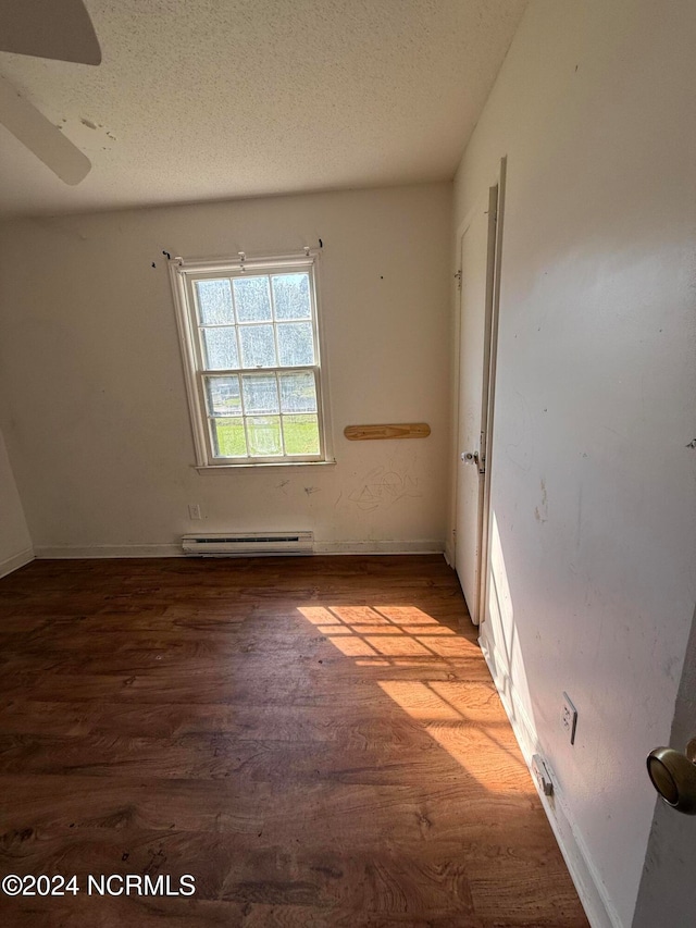 unfurnished room featuring ceiling fan, a textured ceiling, light hardwood / wood-style floors, and a baseboard heating unit