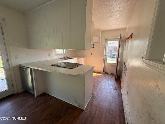 kitchen featuring dark wood-type flooring, kitchen peninsula, a textured ceiling, stainless steel dishwasher, and sink