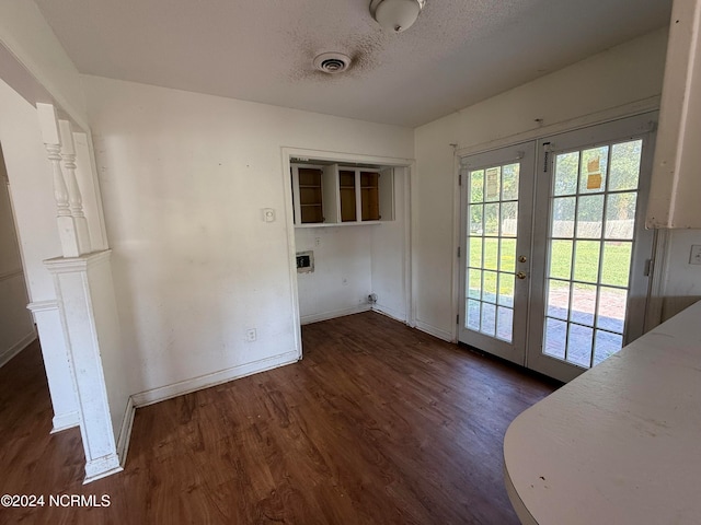 doorway with a textured ceiling, dark wood-type flooring, and french doors