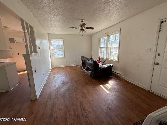 unfurnished room with ceiling fan, a textured ceiling, dark wood-type flooring, and a baseboard heating unit