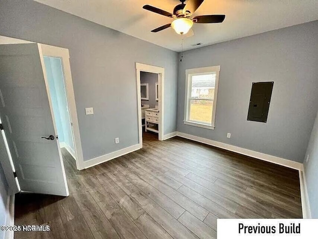 unfurnished bedroom with dark wood-type flooring, ensuite bath, electric panel, and ceiling fan