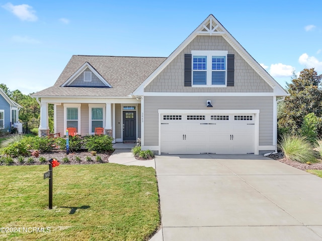 craftsman-style house with a garage, a front lawn, and covered porch