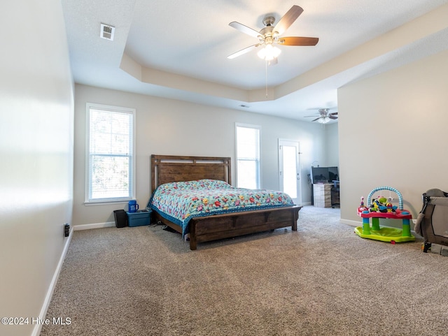 bedroom featuring a tray ceiling, ceiling fan, and carpet floors