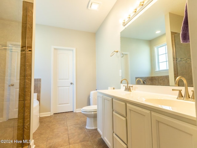 bathroom featuring tile patterned flooring, a tile shower, vanity, and toilet