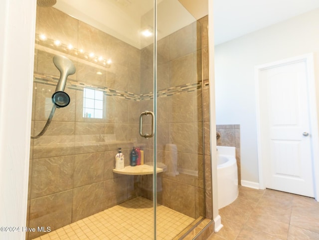 bathroom with tile patterned floors and shower with separate bathtub