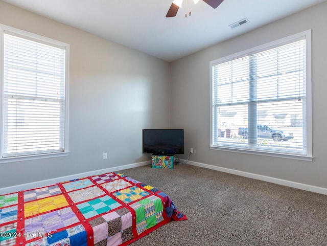 unfurnished bedroom featuring carpet flooring, ceiling fan, and multiple windows