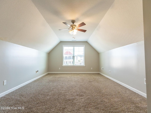 bonus room with a textured ceiling, ceiling fan, carpet, and lofted ceiling