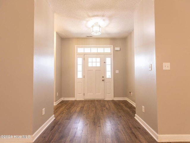 foyer featuring dark hardwood / wood-style flooring and a textured ceiling