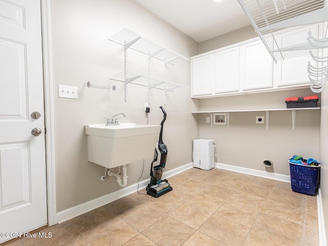 laundry room featuring electric dryer hookup, hookup for a washing machine, and cabinets