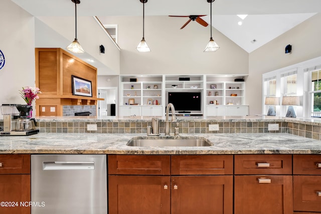 kitchen with light stone counters, high vaulted ceiling, dishwasher, decorative light fixtures, and sink