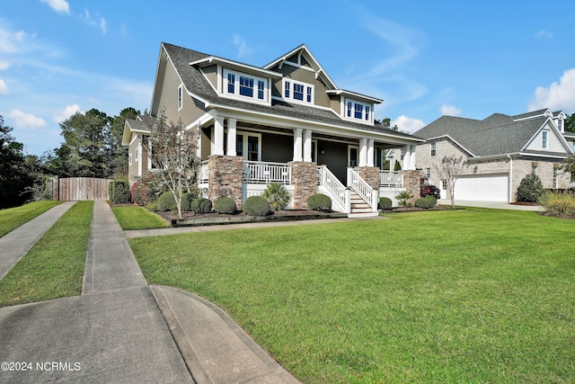 craftsman-style home with a garage, a front lawn, and covered porch