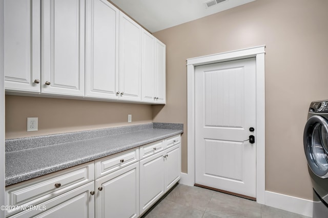 laundry area with cabinets, light tile patterned floors, and washer / dryer