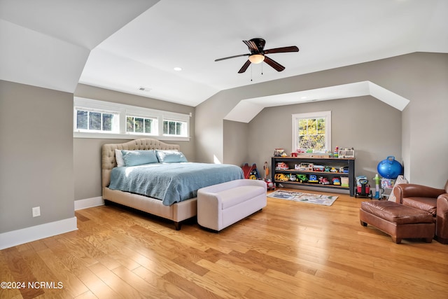 bedroom featuring light hardwood / wood-style flooring, lofted ceiling, multiple windows, and ceiling fan