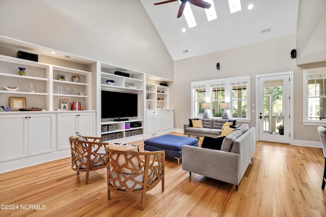 living room with light hardwood / wood-style flooring, ceiling fan, and high vaulted ceiling