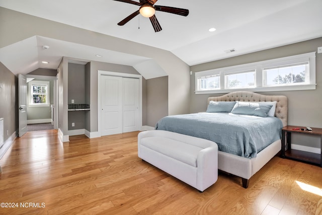 bedroom featuring vaulted ceiling, ceiling fan, a closet, and light hardwood / wood-style flooring