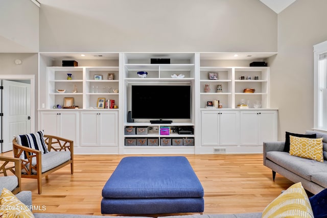 living room featuring light hardwood / wood-style flooring and high vaulted ceiling