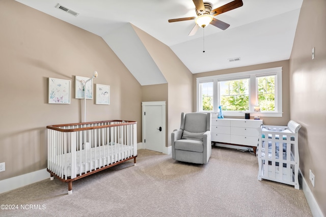 carpeted bedroom featuring vaulted ceiling, ceiling fan, and a nursery area