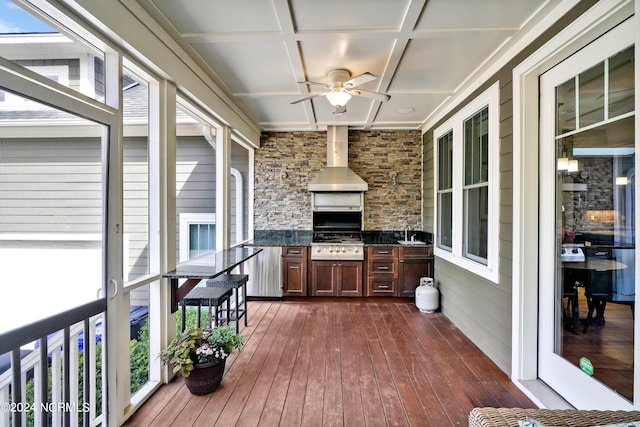 deck with area for grilling, ceiling fan, an outdoor kitchen, and sink