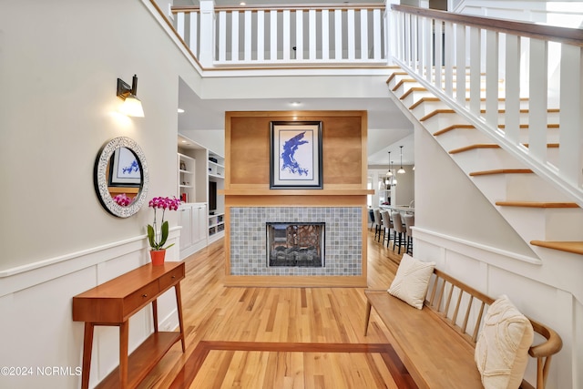 living room featuring a high ceiling, a fireplace, and hardwood / wood-style floors