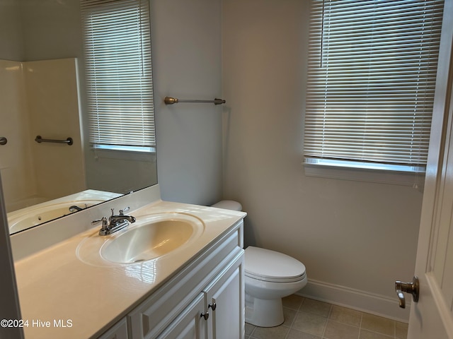 bathroom with vanity, toilet, a wealth of natural light, and tile patterned flooring