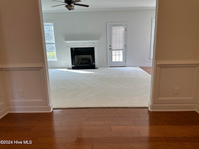 unfurnished living room with ornamental molding, hardwood / wood-style flooring, and ceiling fan