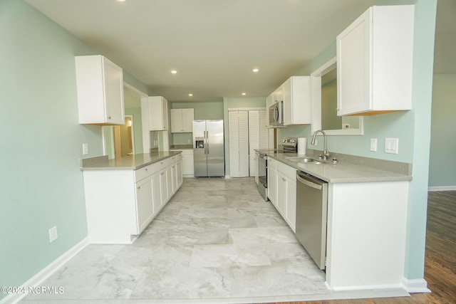 kitchen with light hardwood / wood-style floors, sink, stainless steel appliances, and white cabinets