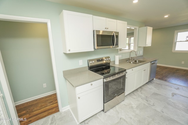 kitchen featuring white cabinets, light hardwood / wood-style floors, stainless steel appliances, and sink