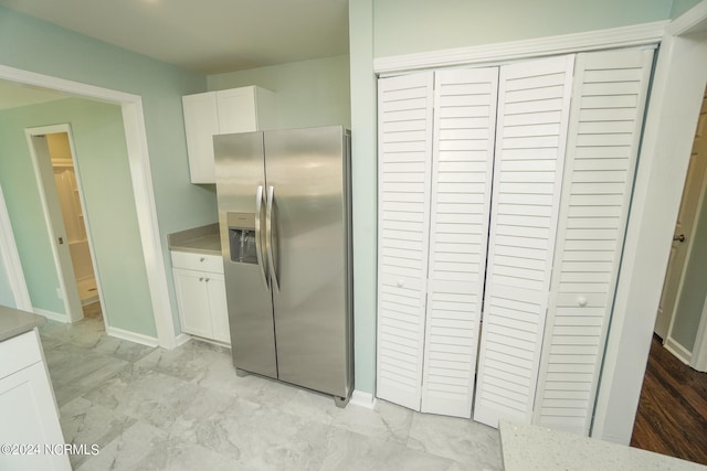 kitchen featuring white cabinets and stainless steel fridge with ice dispenser