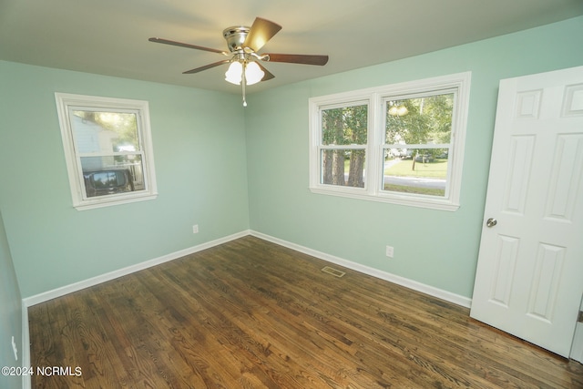 empty room with ceiling fan and dark hardwood / wood-style flooring