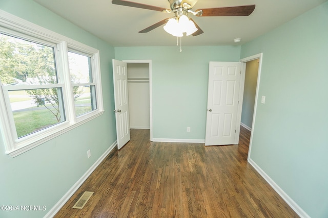 unfurnished bedroom with dark hardwood / wood-style flooring, ceiling fan, and a closet