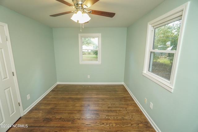 spare room with dark wood-type flooring, ceiling fan, and plenty of natural light