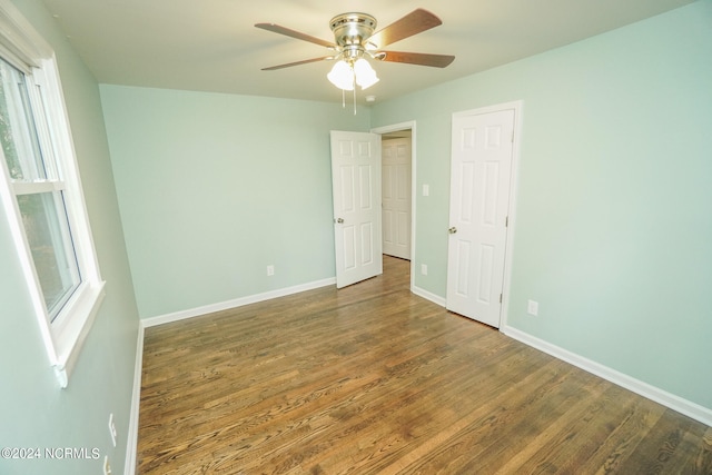 unfurnished room with ceiling fan, dark hardwood / wood-style floors, and a wealth of natural light