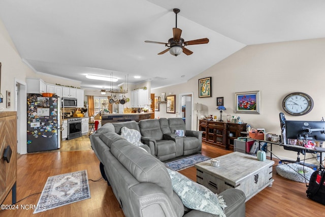 living room with ceiling fan, light wood-type flooring, and vaulted ceiling