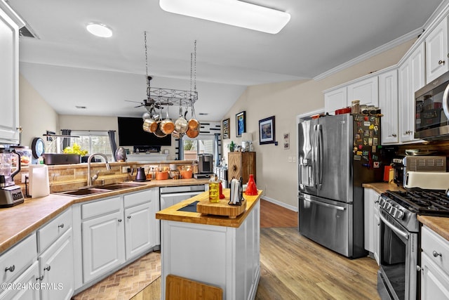 kitchen featuring wooden counters, appliances with stainless steel finishes, sink, and white cabinets