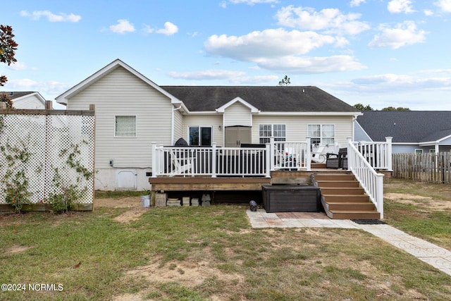 back of property with a lawn and a wooden deck