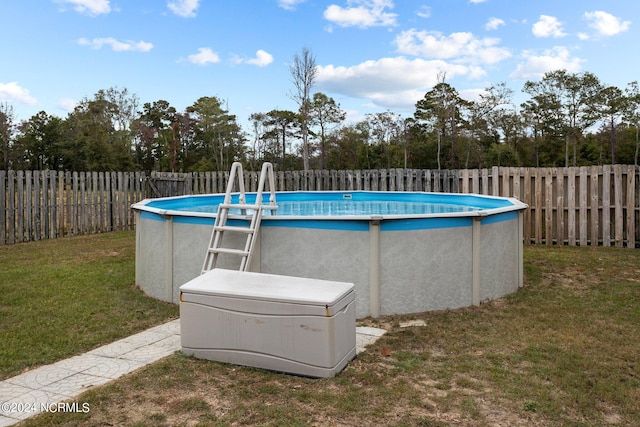 view of pool with a yard