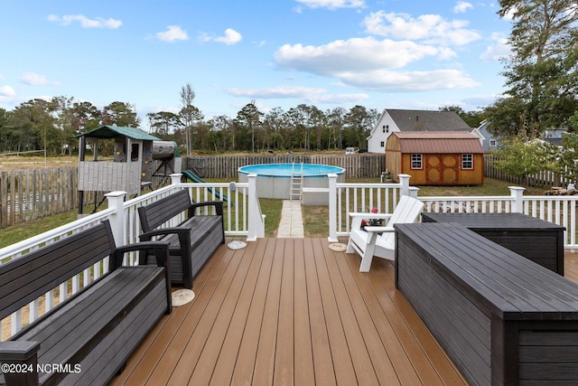 deck with a storage shed and a fenced in pool