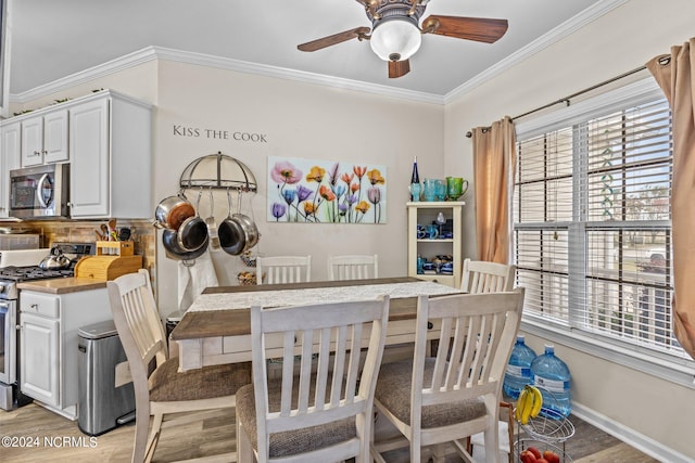 kitchen with ornamental molding, white cabinetry, appliances with stainless steel finishes, light wood-type flooring, and ceiling fan