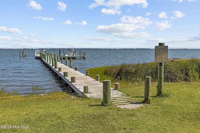 dock area featuring a water view and a lawn