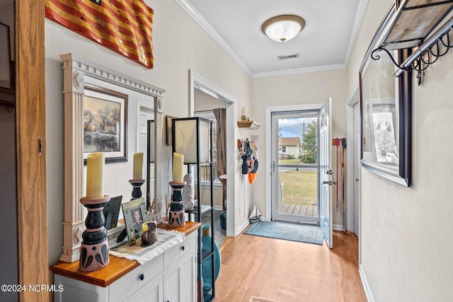 doorway to outside with light wood-type flooring and crown molding