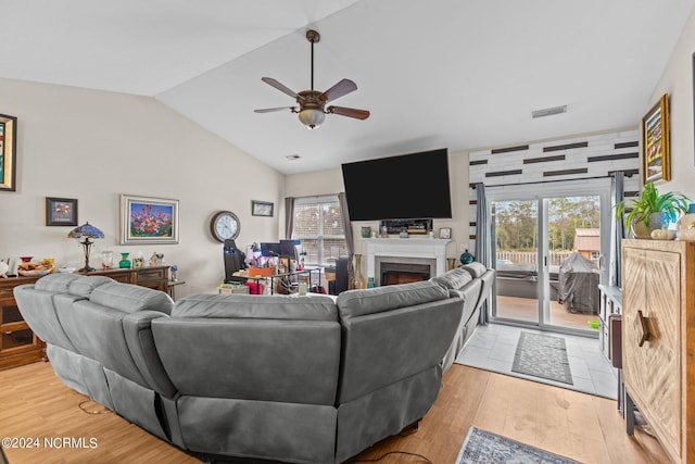 living room with a wealth of natural light, ceiling fan, lofted ceiling, and light hardwood / wood-style floors