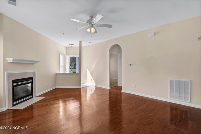 unfurnished living room featuring ceiling fan, light wood-type flooring, and a tile fireplace