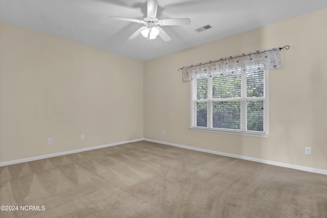 empty room with visible vents, carpet, ceiling fan, and baseboards