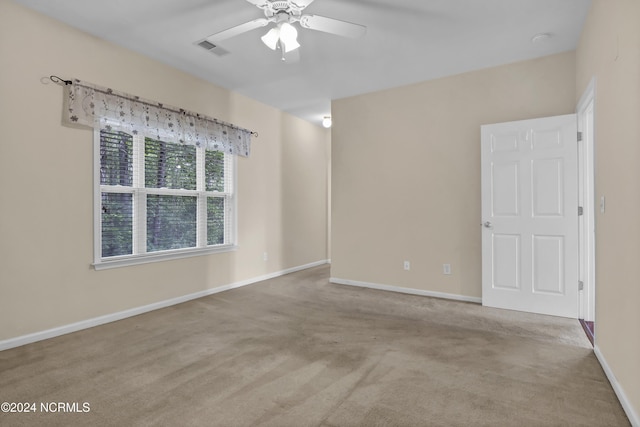 unfurnished room with carpet floors, a ceiling fan, baseboards, and visible vents